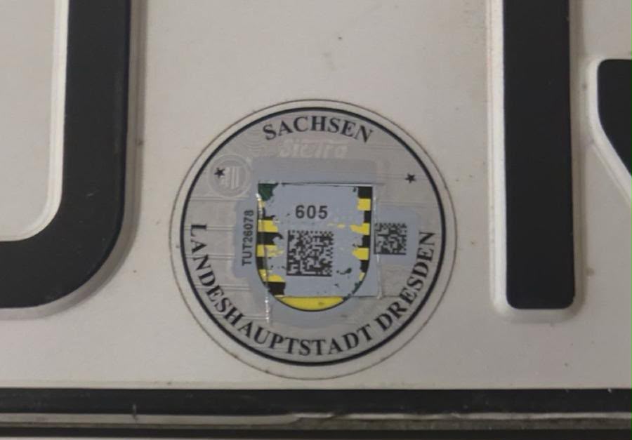 Vorderes Kennzeichen Zoom auf die Landesplakette mit freigelegtem Code